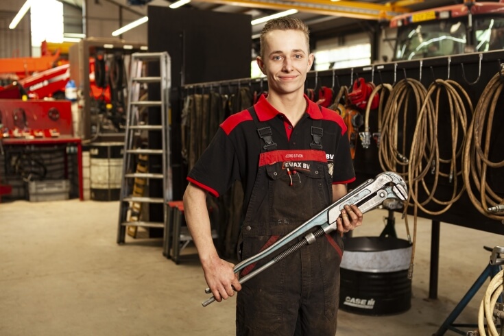 Monteur met grote moersleutel in werkplaats.